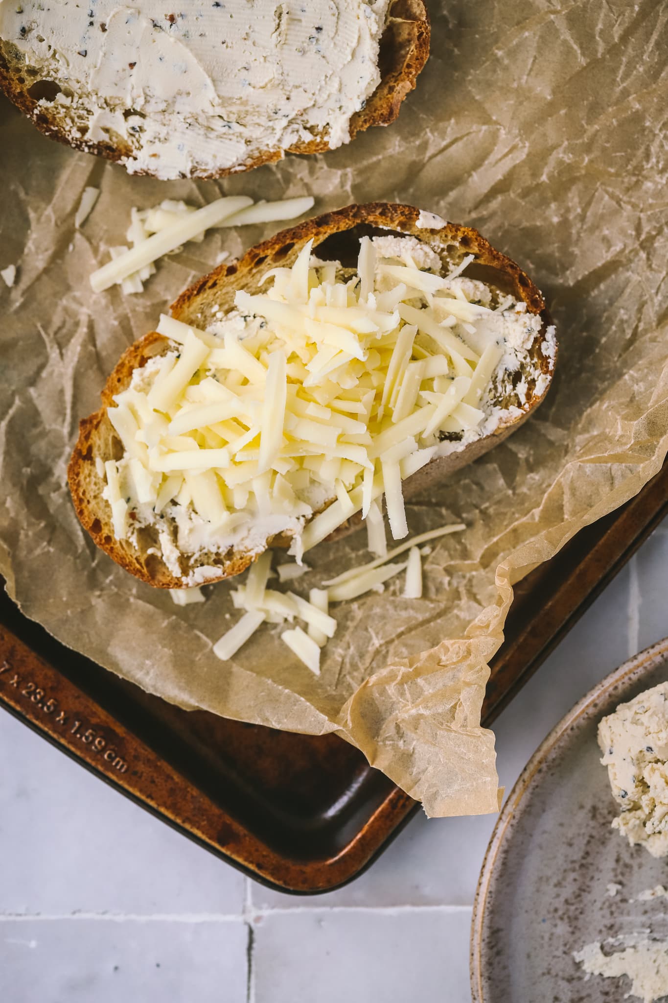 bread topped with shredded cheese on a sheet pan