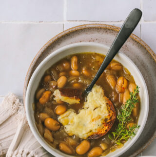 top view of french onion soup with cheesy toast and spoon