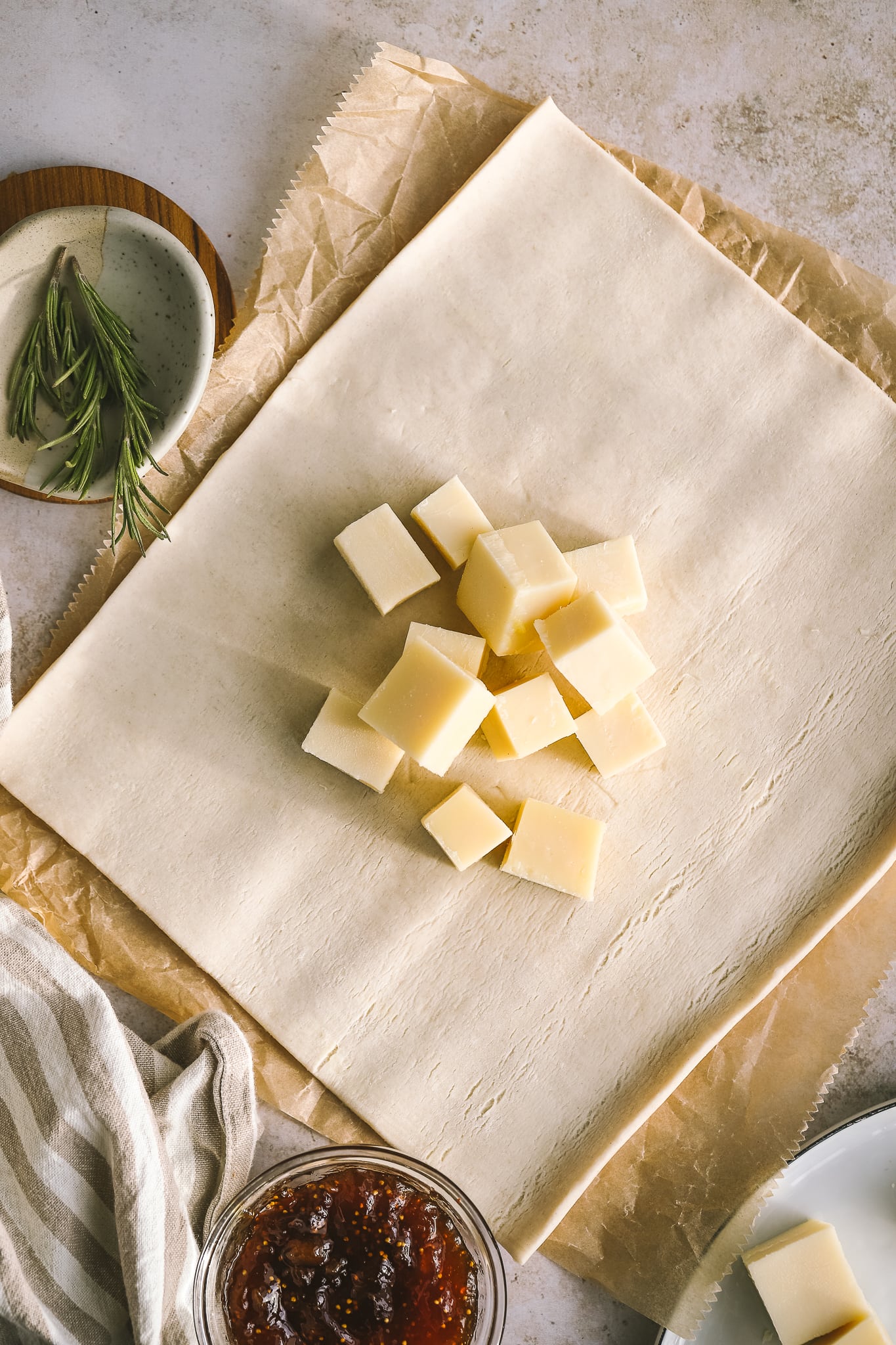 cubed gruyere cheese on a sheet of puff pastry