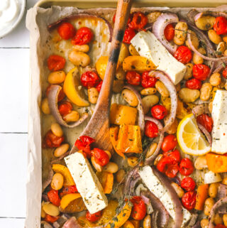 overhead photo of sheet pan dinner with feta with a serving spoon