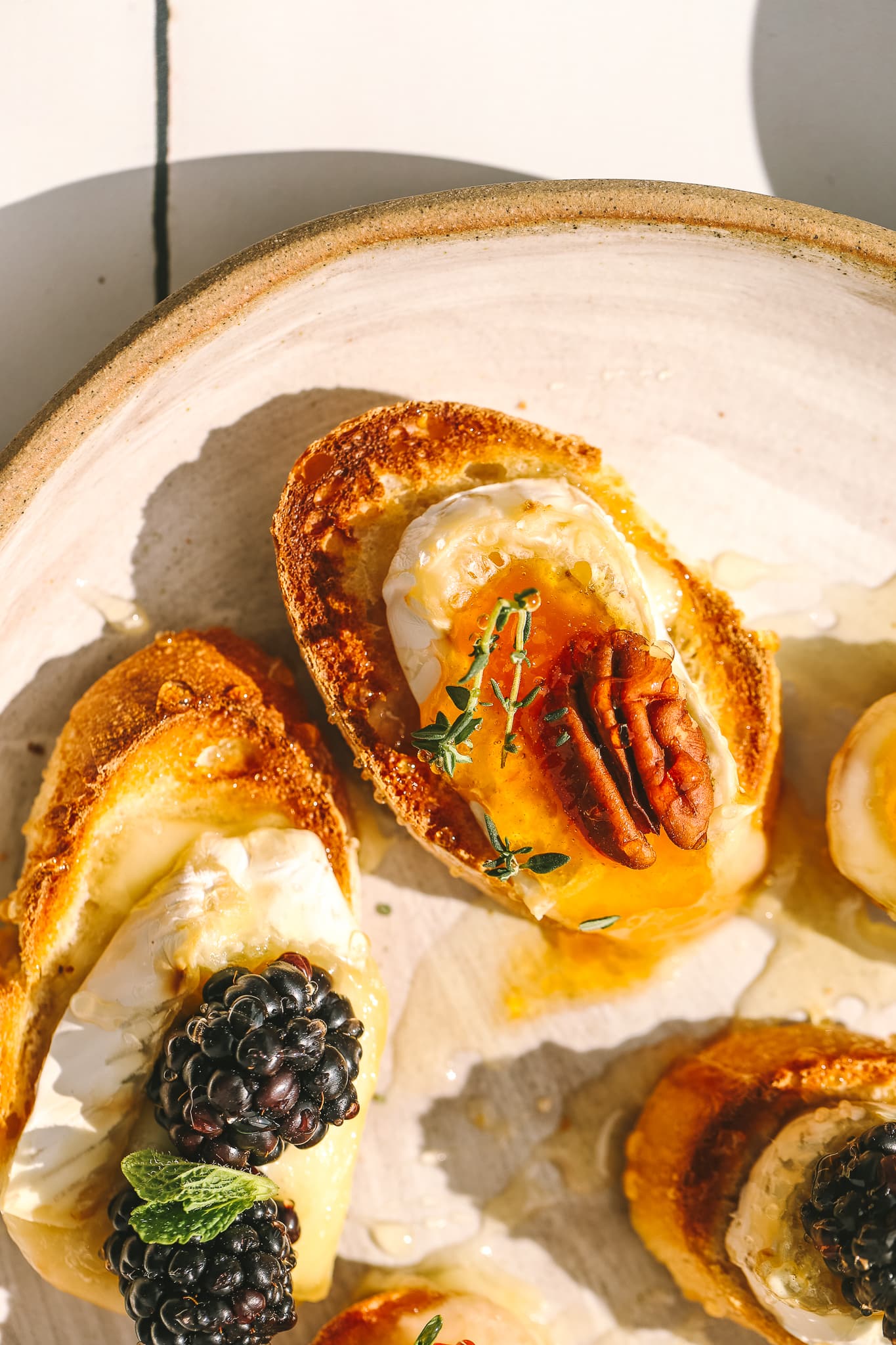 side angle close-up of apricot jam and brie on a crostini