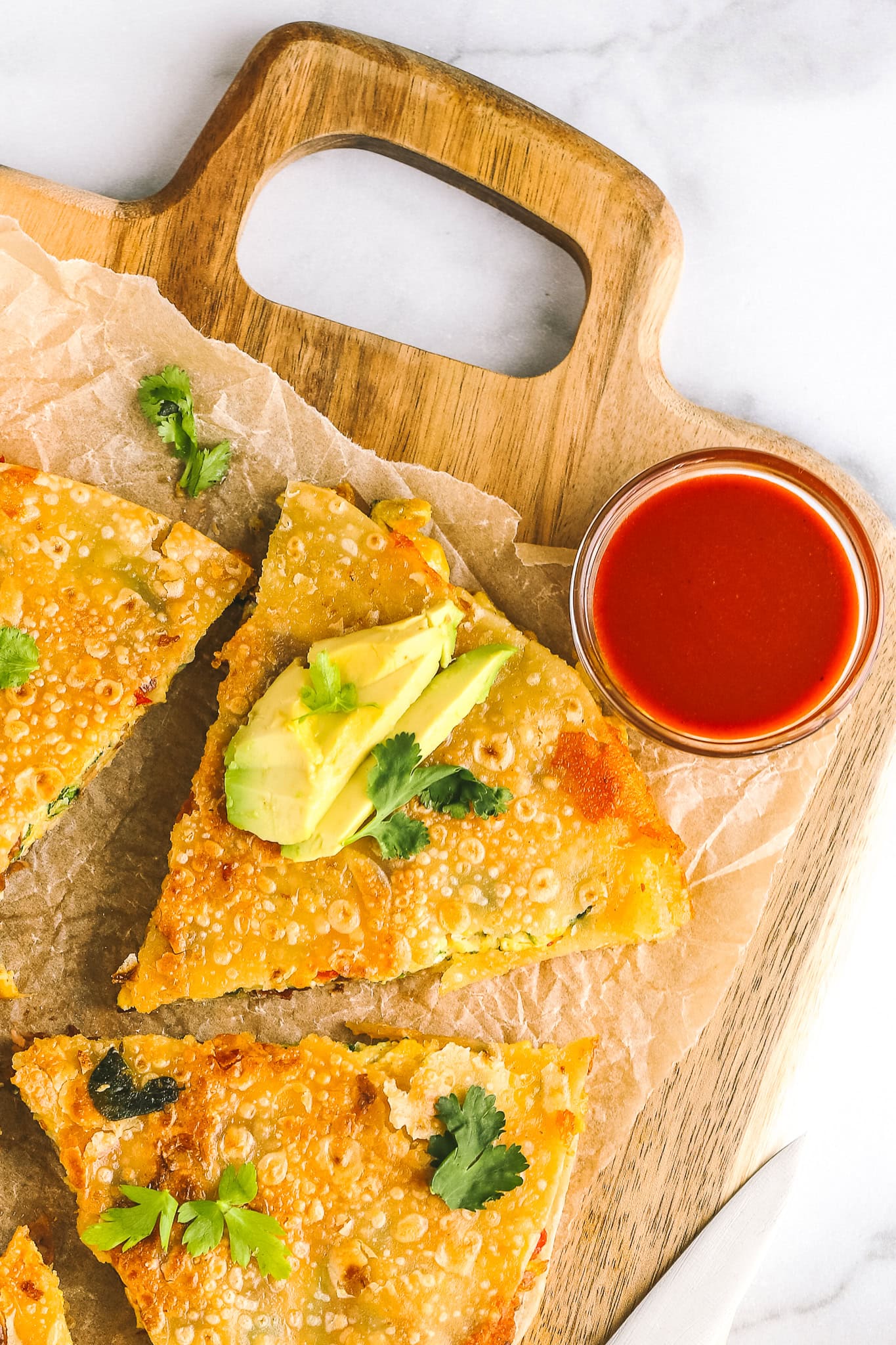 one slice of breakfast quesadilla with hot sauce