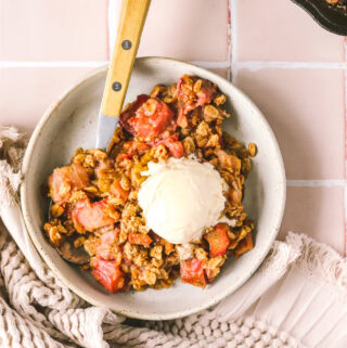 overhead shot rhubarb crisp in a bowl with ice cream