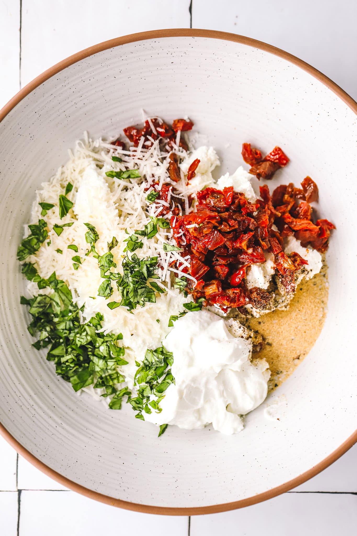 sundried tomatoes, basil, parmesan cheese and yogurt in a bowl