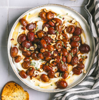 overhead of whipped ricotta with roasted grapes and crostini