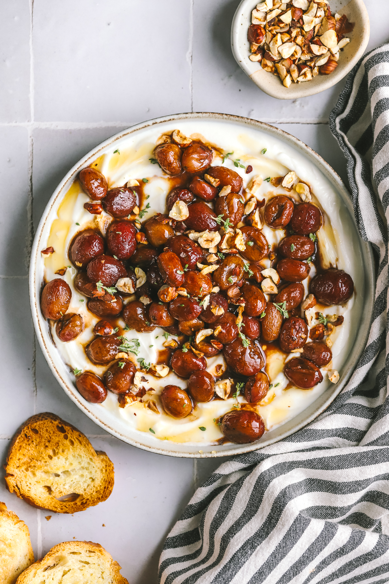 overhead of whipped ricotta with roasted grapes and crostini