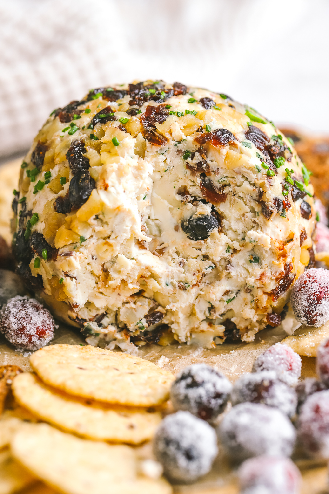 cranberry walnut cheese ball with slices out of it