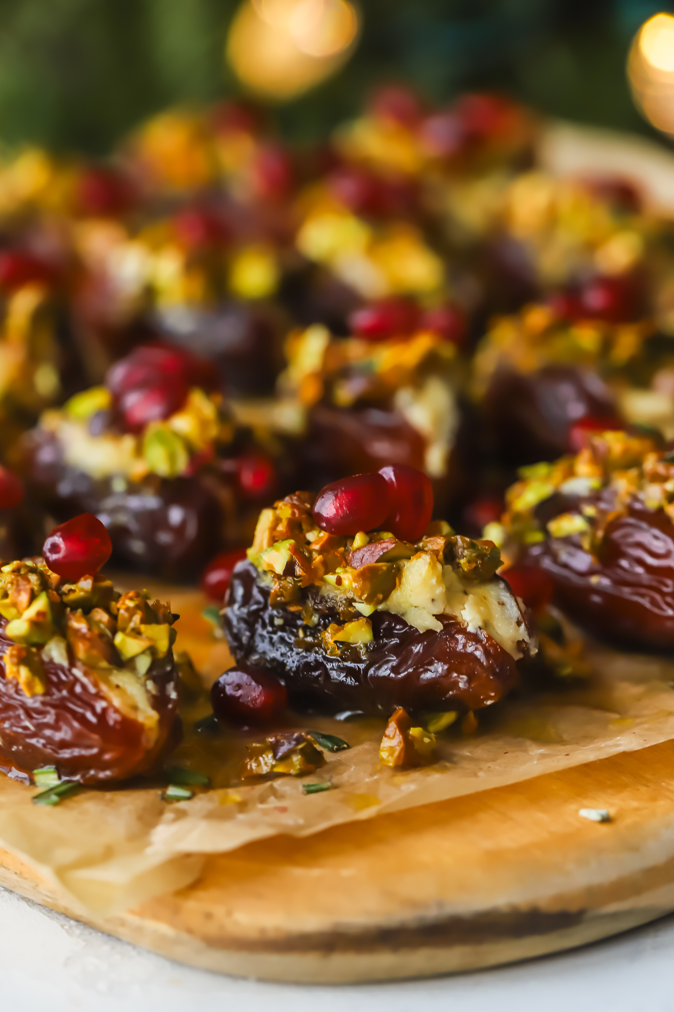stuffed date on a serving tray with pistachios and pomegranate seeds
