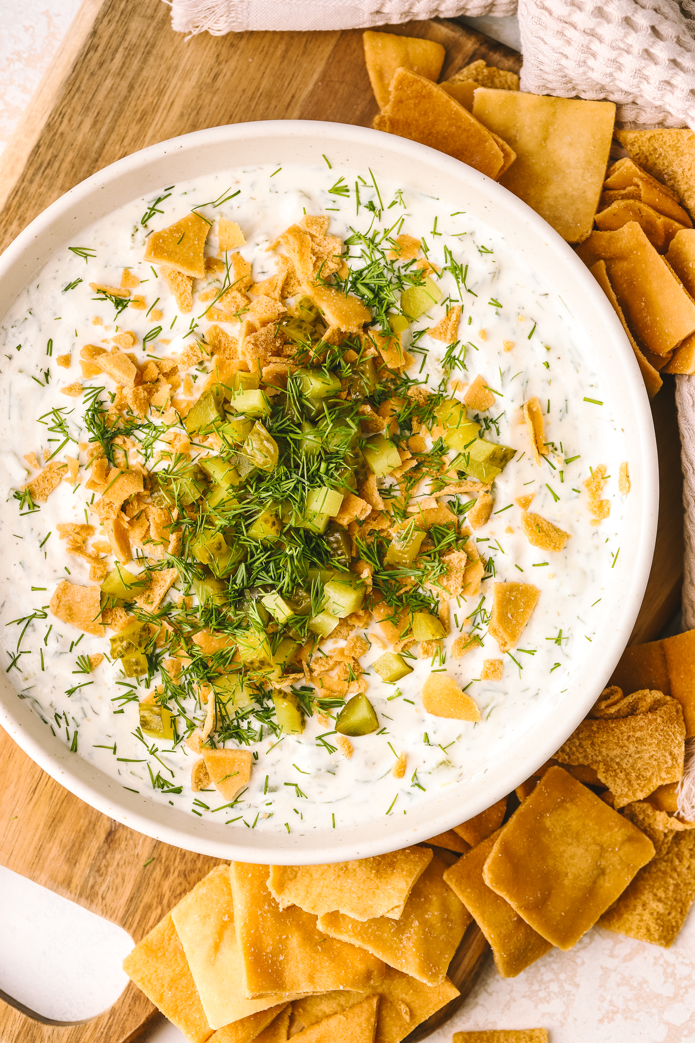 high protein dill pickle dip in a bowl served with pita chips 
