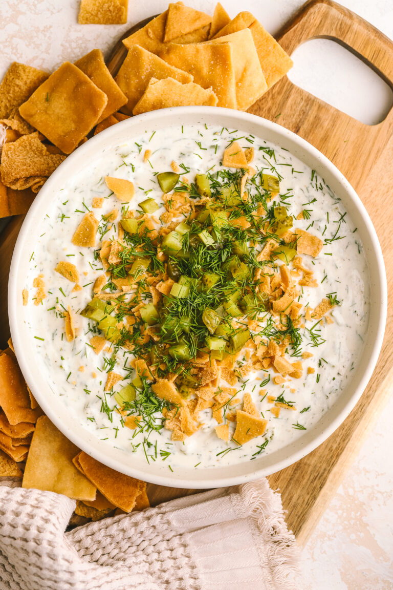 high protein dill pickle dip in a bowl served with pita chips