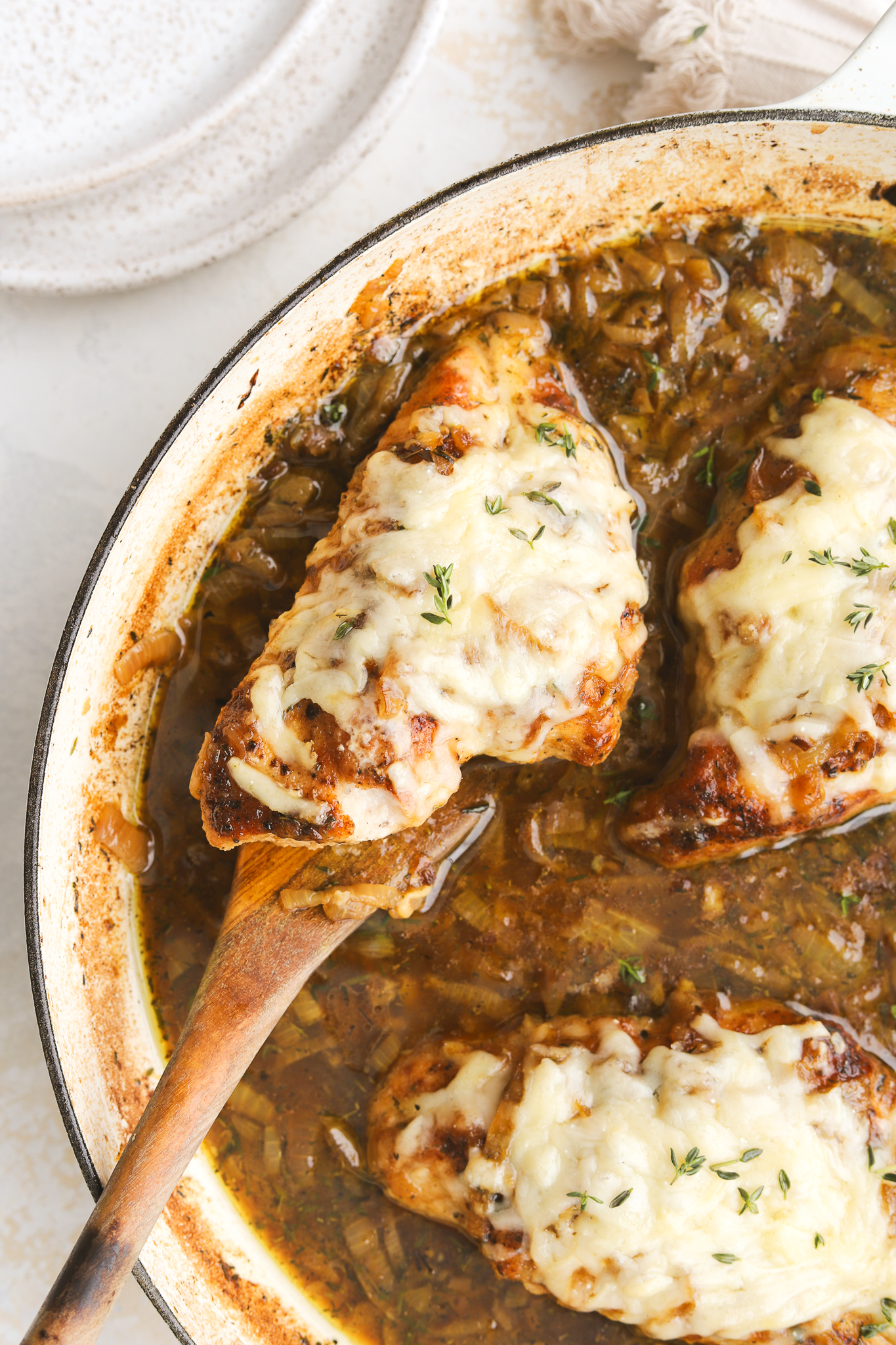 serving spoon holding cooked french onion chicken