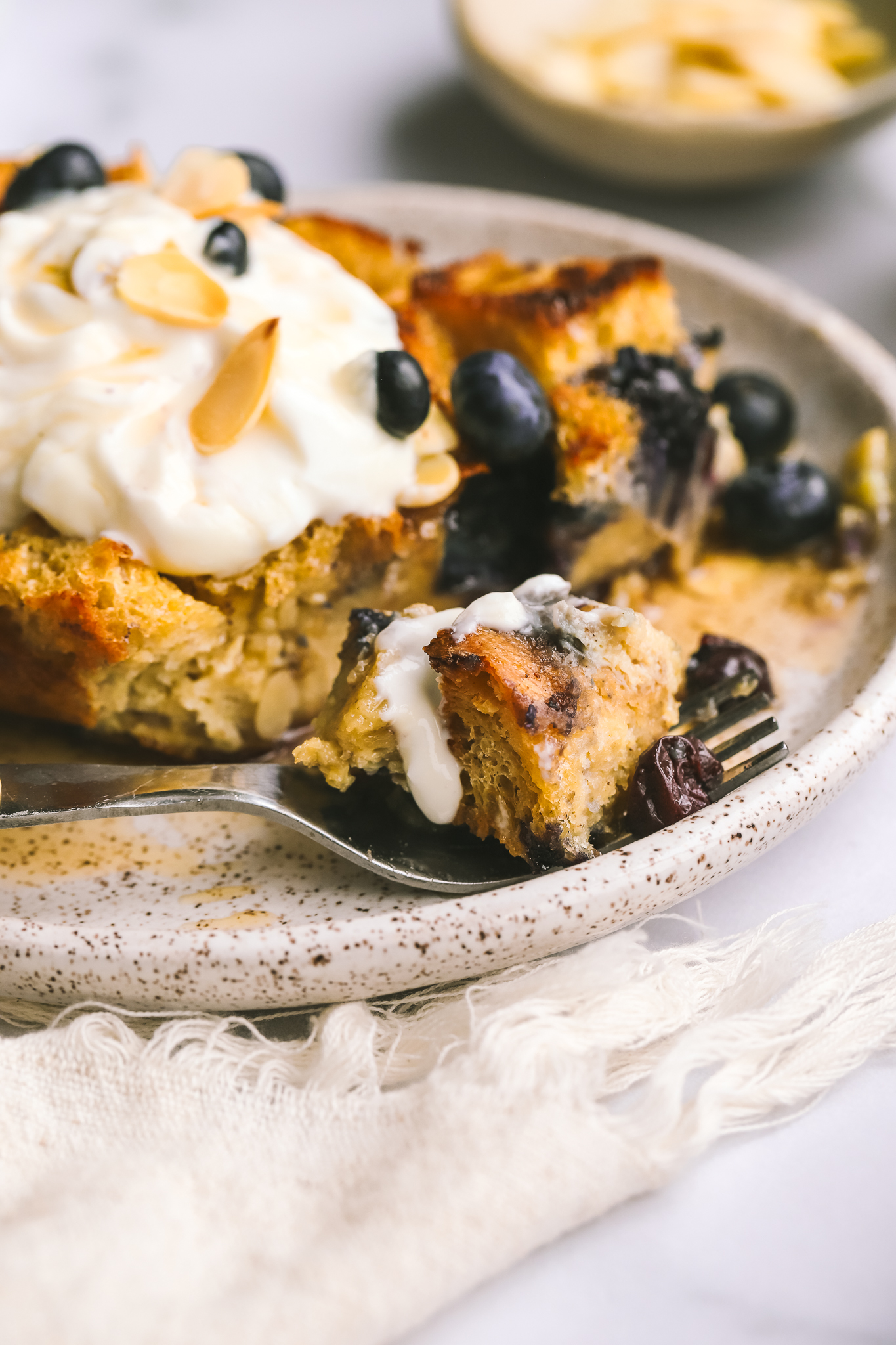 a piece of blueberry baked french toast being eaten with a fork