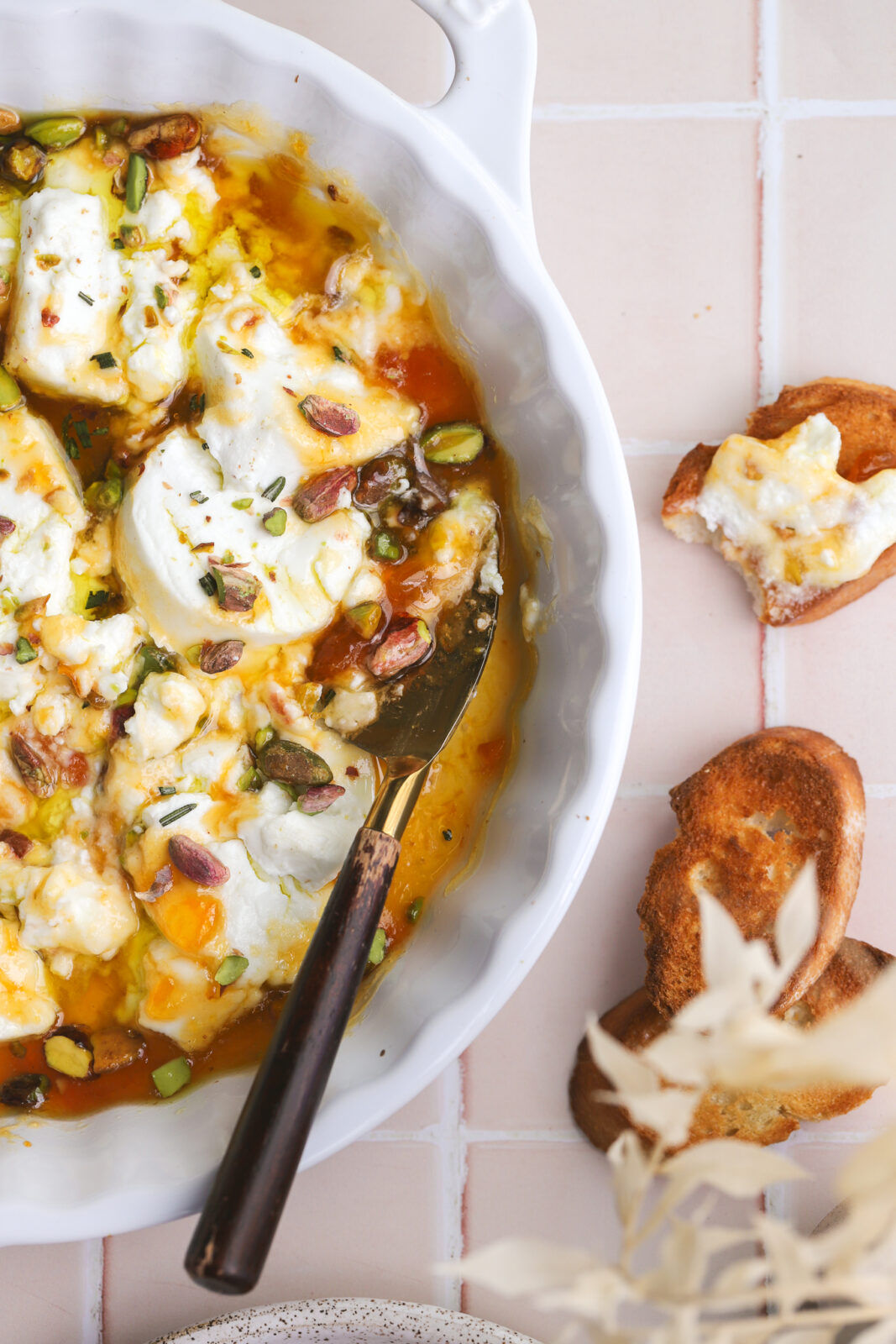 cheese knife serving baked goat cheese on crostini