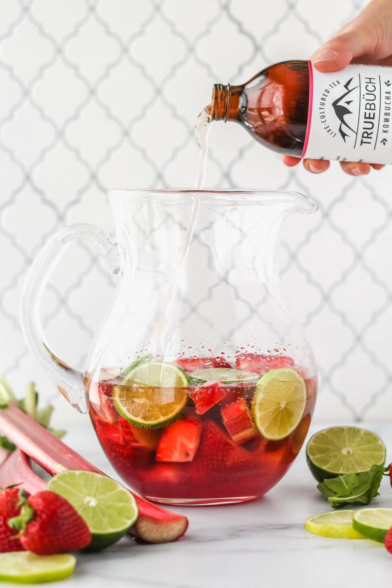 kombucha being poured into a pitcher
