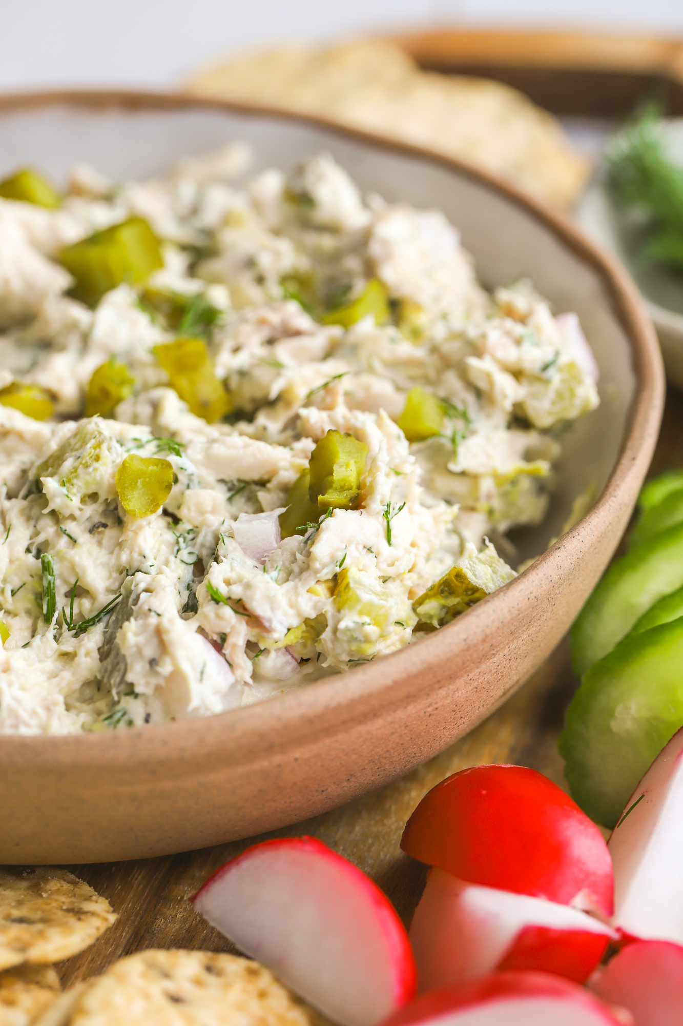 close up of chicken salad with pickles and dill