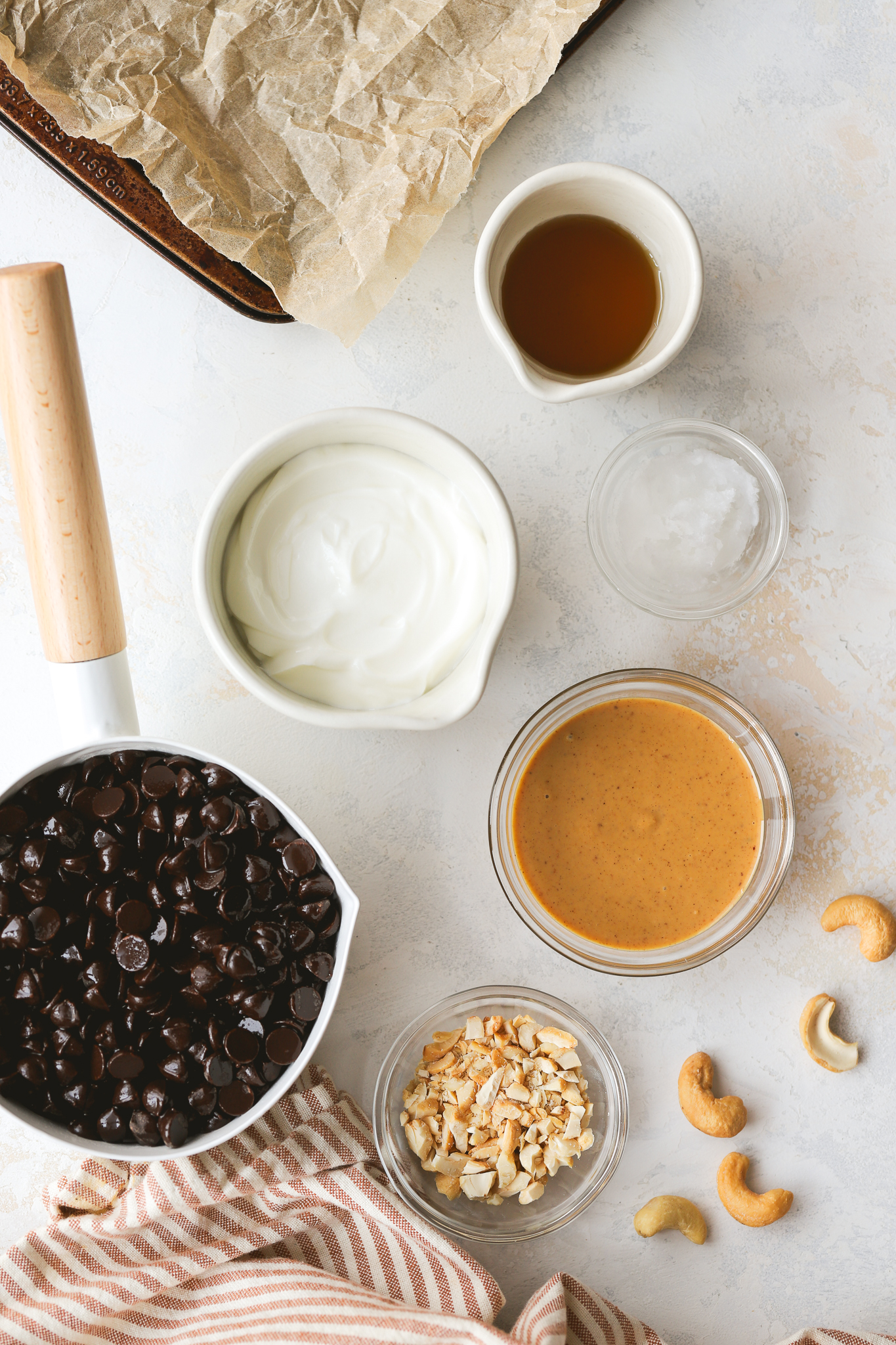 chocolate chips, yogurt, peanut butter, nuts and maple syrup in bowls