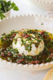 ball of burrata in a bowl drizzle with olive oil and herbs