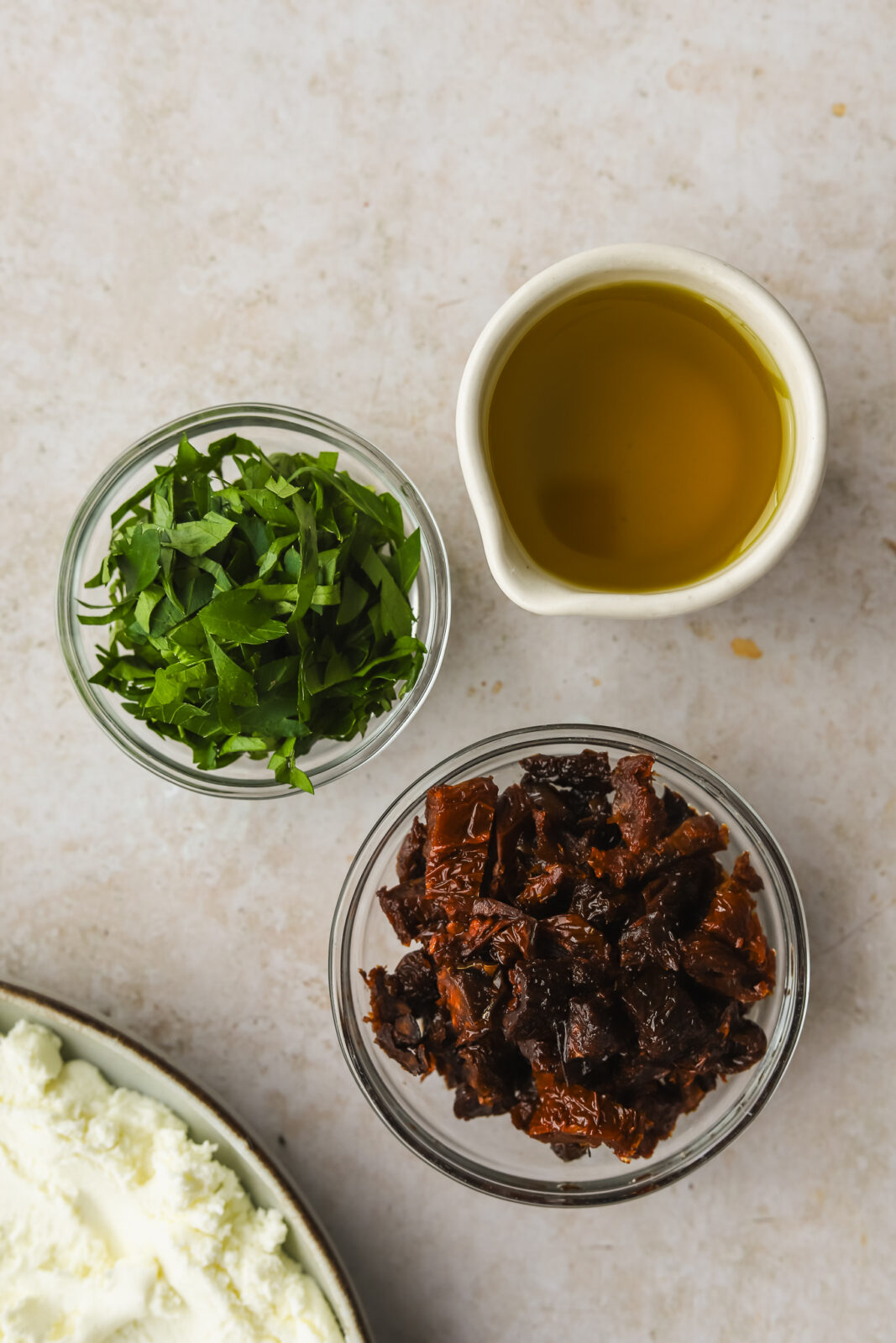 olive oil, fresh herbs and sundried tomatoes in bowls
