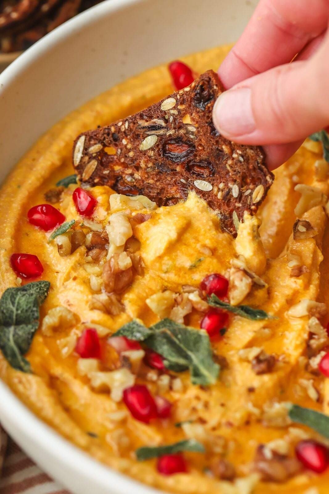 cracker dipping into pumpkin dip