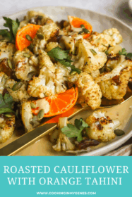 roasted cauliflower in a serving dish with orange tahini sauce