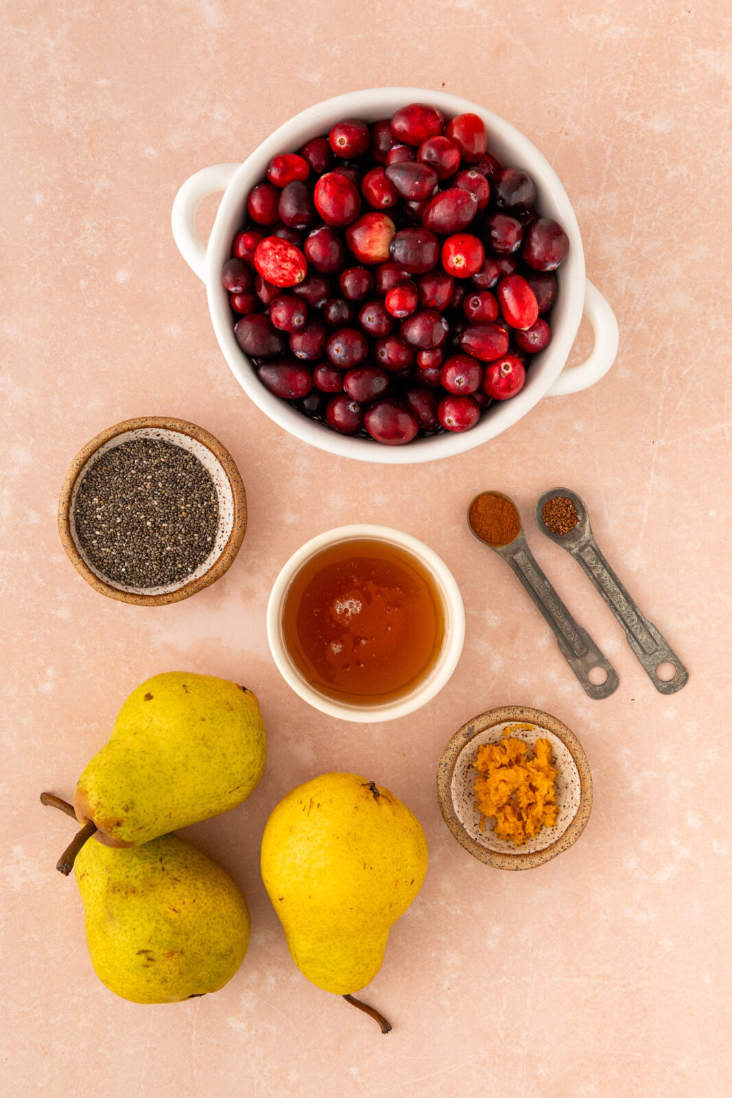 cranberries, honey, chia seeds in bowls with pears