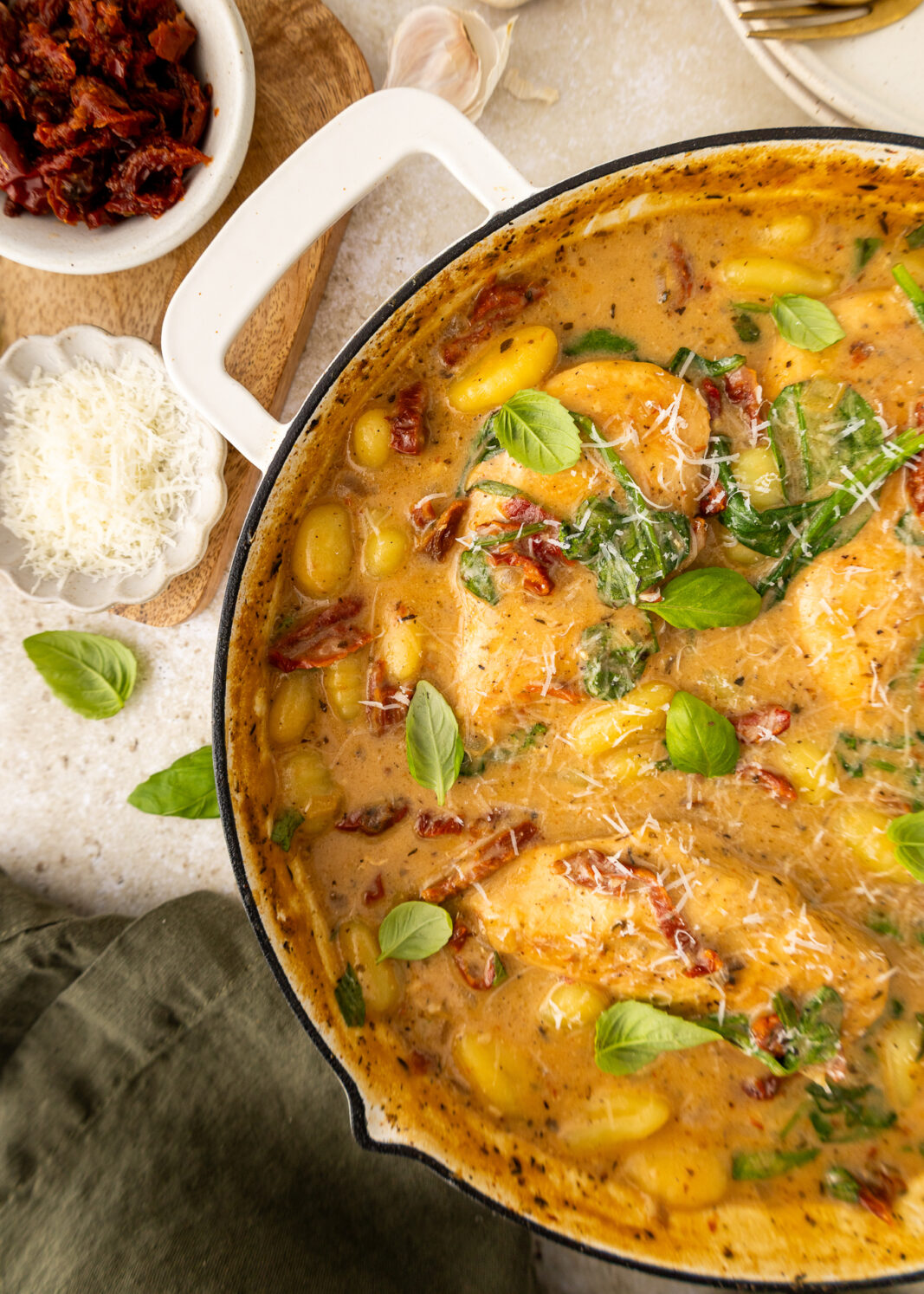 close up of marry me chicken and gnocchi in a pan with fresh basil