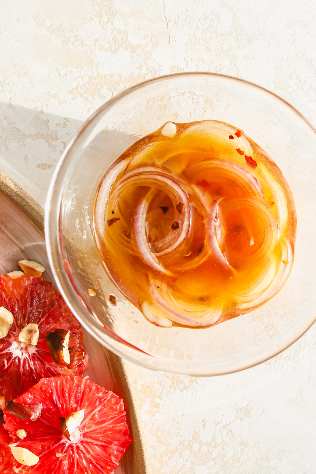 close up of shallots in a bowl with dressing