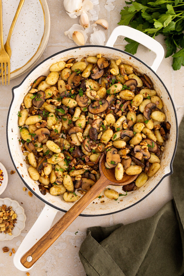 gnocchi side dish with mushrooms, walnuts and parsley in a pan