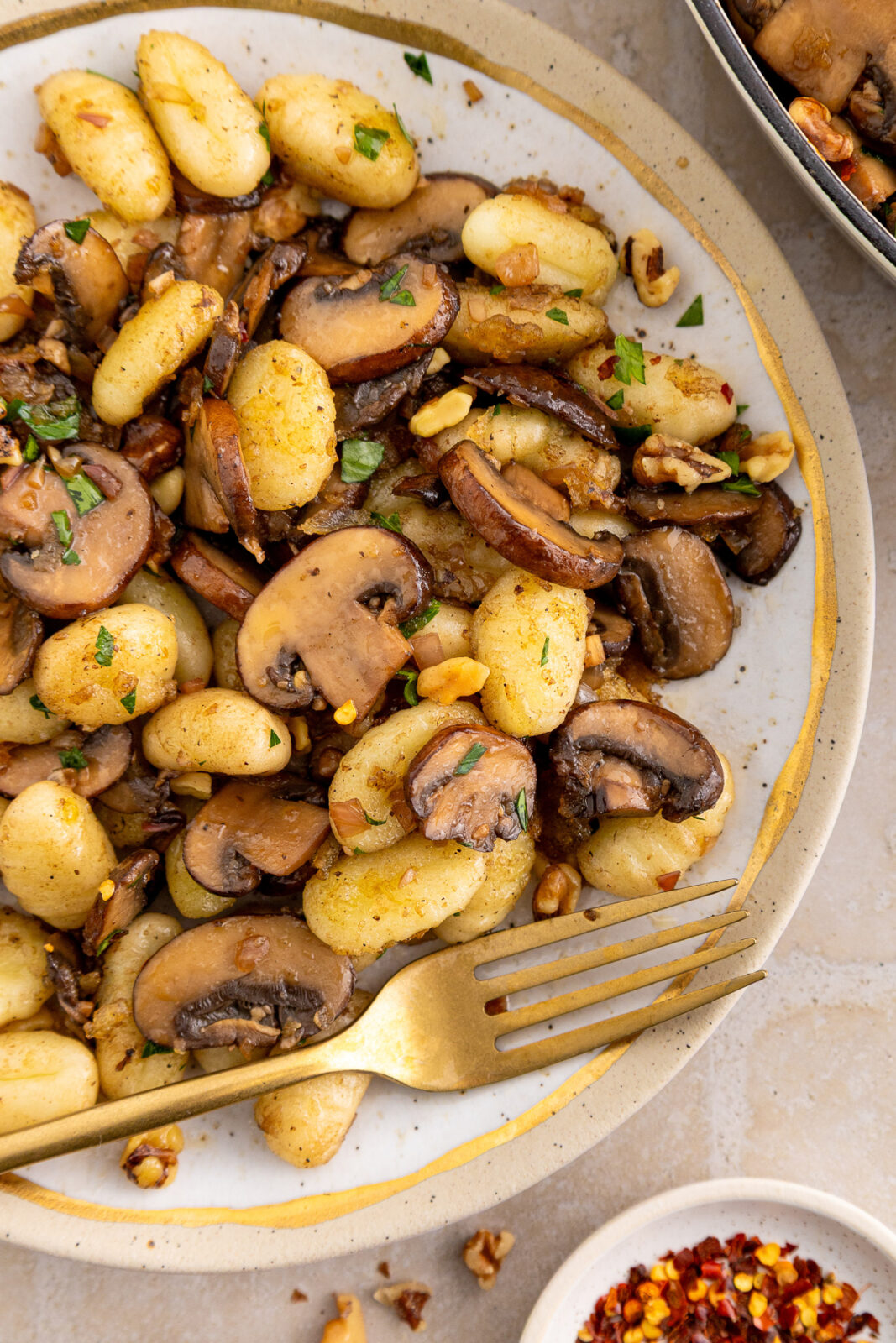 gnocchi and mushrooms side dish on a plate with a fork