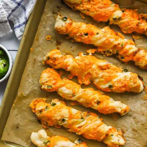 baked jalapeno popper cheese twists on a baking sheet